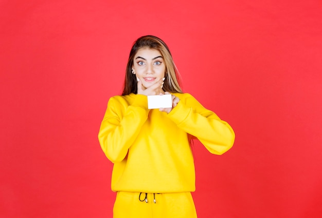 Foto grátis retrato de mulher jovem e bonita com cartão de visita em branco em pé