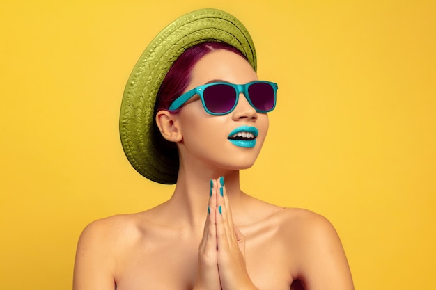 Foto grátis retrato de mulher jovem e bonita com maquiagem brilhante isolada em amarelo