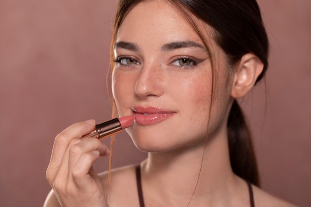 Retrato de mulher jovem e bonita com um produto de maquiagem