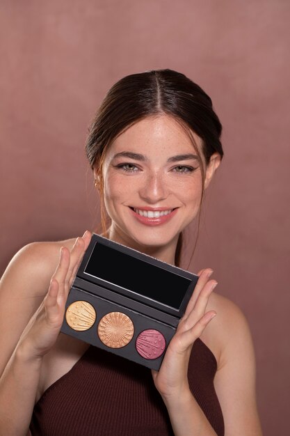Retrato de mulher jovem e bonita com um produto de maquiagem