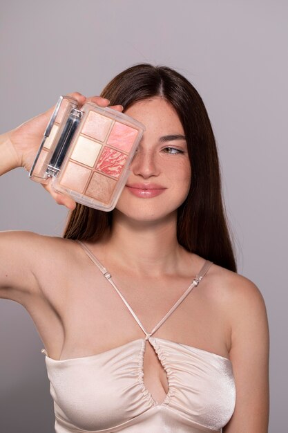 Retrato de mulher jovem e bonita com um produto de maquiagem