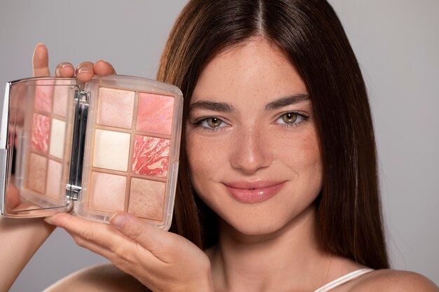 Retrato de mulher jovem e bonita com um produto de maquiagem