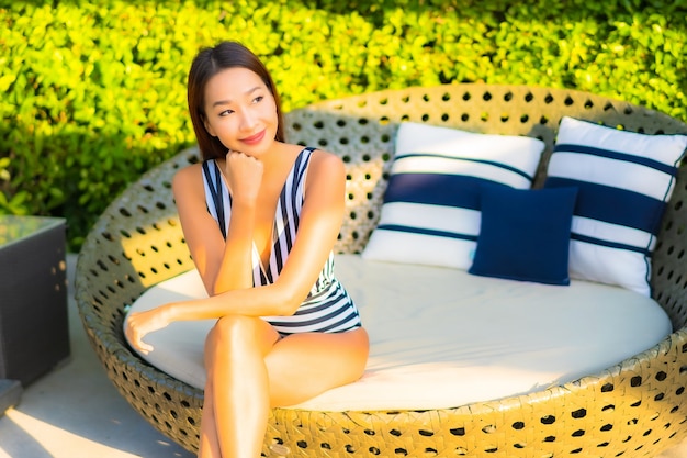 Retrato de mulher jovem e bonita relaxando sorriso lazer nas férias ao redor da piscina em hotel resort