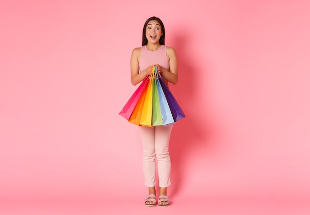 Retrato de mulher jovem expressiva com sacolas de compras