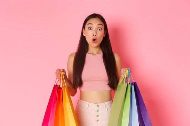 Retrato de mulher jovem expressiva com sacolas de compras