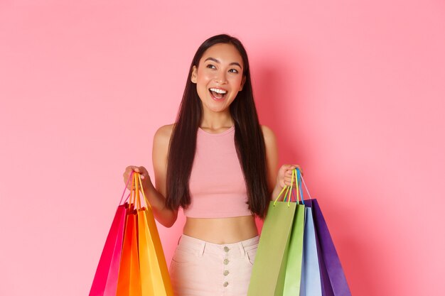 Retrato de mulher jovem expressiva com sacolas de compras