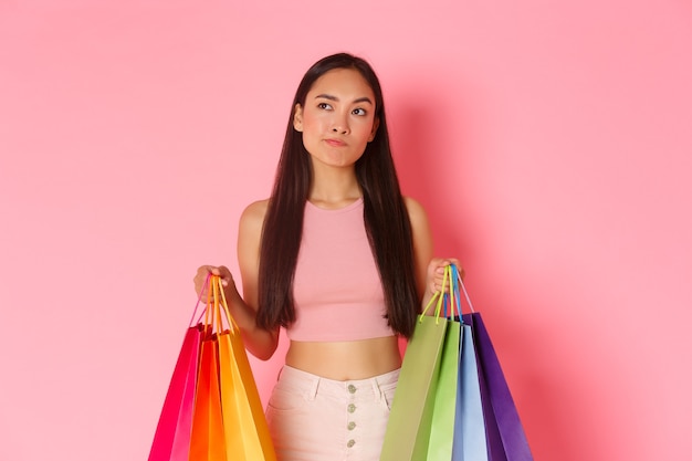 Retrato de mulher jovem expressiva com sacolas de compras