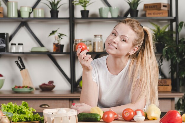 Retrato, de, mulher jovem, segurando, tomate vermelho