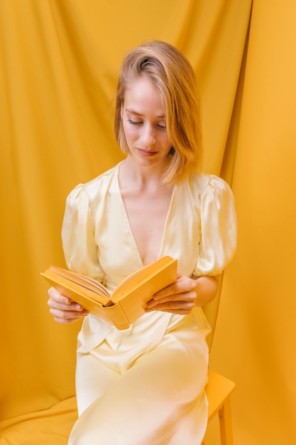 Retrato, de, mulher, lendo um livro, em, um, amarela, cena