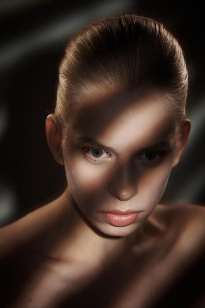 Retrato de mulher loira com sombras e luzes no rosto.