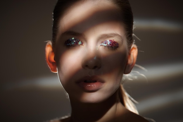 Retrato de mulher loira com sombras e luzes no rosto.