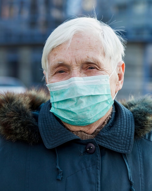 Retrato de mulher mais velha usando máscara médica enquanto estava na cidade