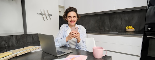 Foto grátis retrato de mulher morena bate-papo no telefone celular usa aplicativo de smartphone de casa encomendas entrega enquanto