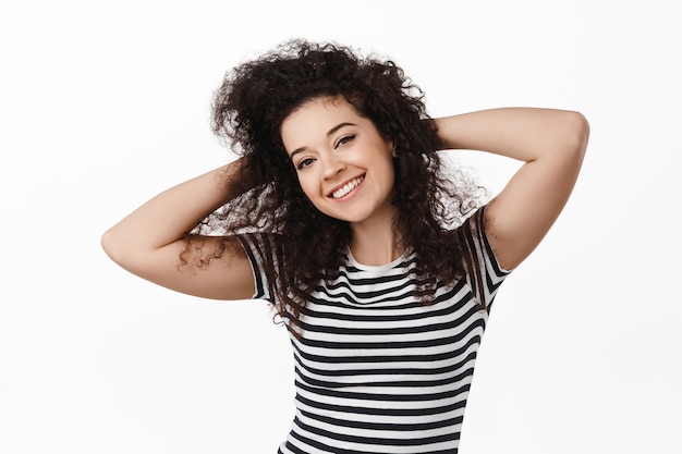 Foto grátis retrato de mulher morena feliz encaracolada em branco