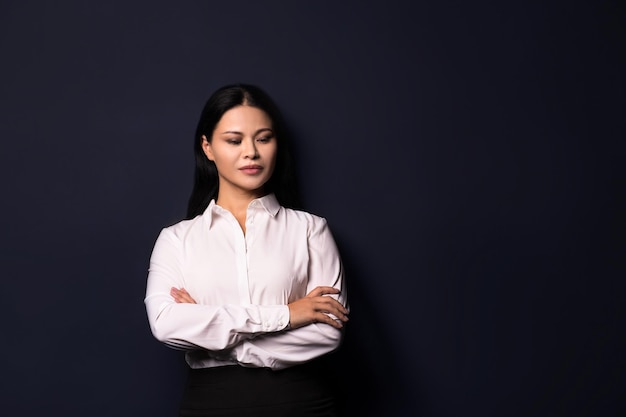 Retrato de mulher morena linda jovem elegantemente vestida. Olhando de lado. Vestindo roupas de escritório.