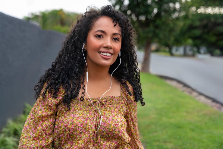 Foto grátis retrato de mulher ouvindo música em fones de ouvido ao ar livre