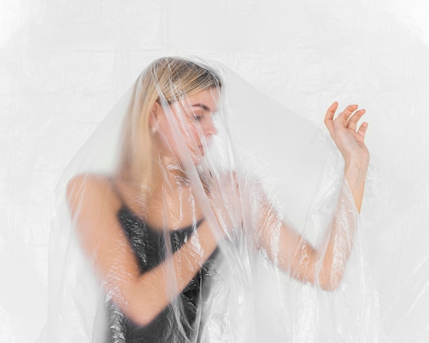 Retrato de mulher posando com folha de plástico