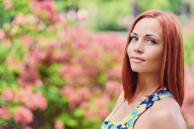 Retrato de mulher ruiva sorridente no parque.