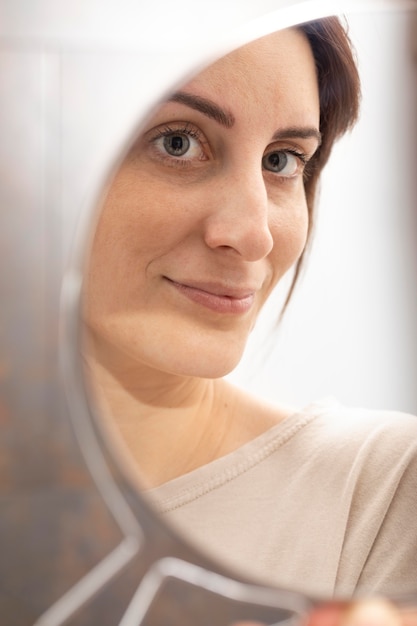 Retrato de mulher se olhando no espelho após o tratamento com microblading