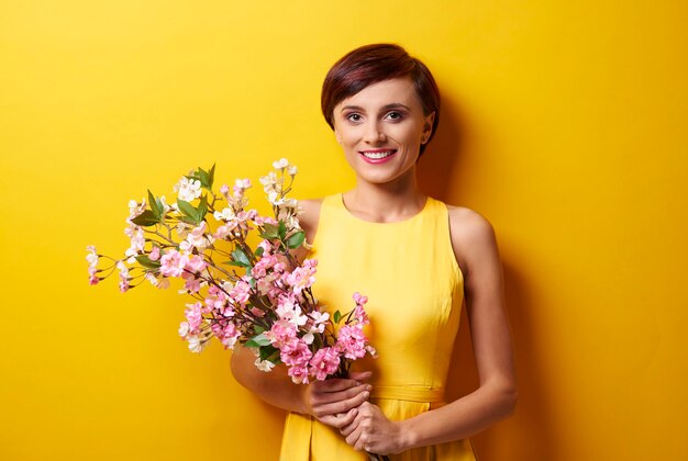 Retrato de mulher segurando flores cor de rosa