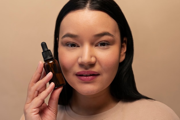 Foto grátis retrato de mulher segurando frasco de soro com conta-gotas