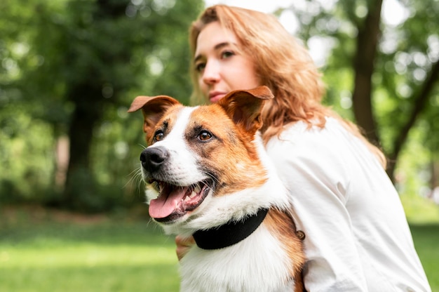 Retrato de mulher segurando seu cachorro no parque