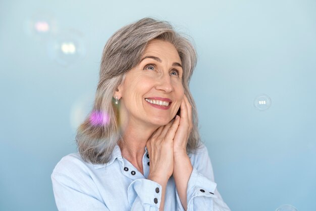 Retrato de mulher sorridente, posando enquanto brinca com bolhas