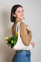 Foto grátis retrato de mulher sorridente segurando compras ecológicas