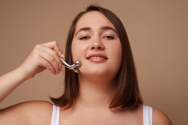 Retrato de mulher usando rolo facial para beleza