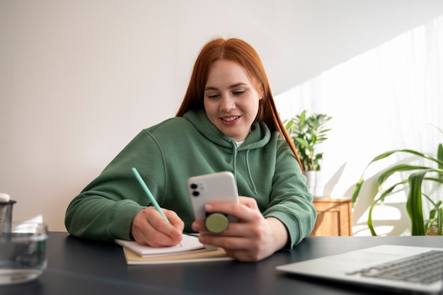 Foto grátis retrato de mulher usando smartphone com pop socket ao ar livre