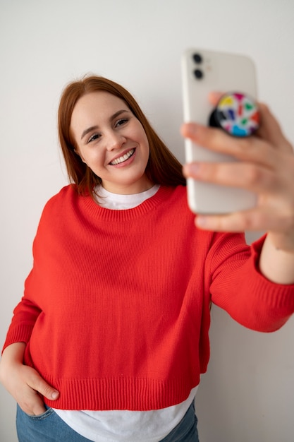 Retrato de mulher usando smartphone em casa com pop socket