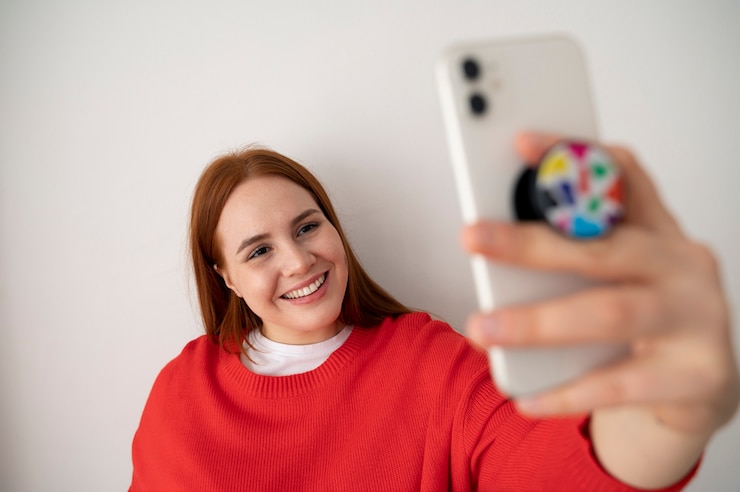 Foto grátis retrato de mulher usando smartphone em casa com pop socket