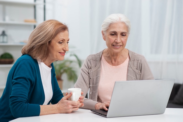 Foto grátis retrato de mulheres bonitos, olhando para um laptop