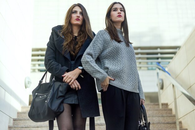 Retrato de mulheres novas bonitas que levantam na rua.