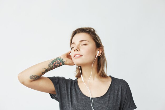 Retrato de música jovem concurso em fones de ouvido com os olhos fechados.