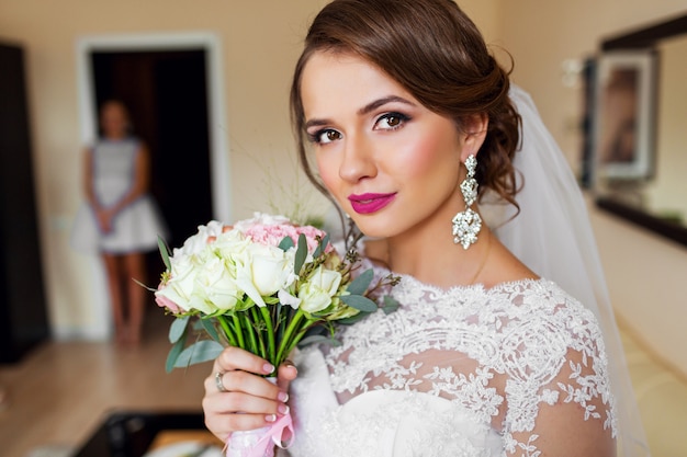 Retrato de noiva linda em vestido de noiva branco brilhante compõem.