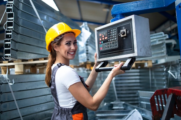 Retrato de operária operando máquina industrial e definindo parâmetros no computador