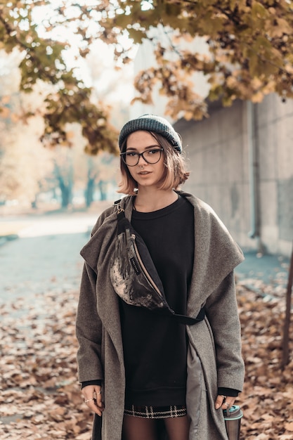 Retrato de outono ao ar livre de jovem, andando na rua da cidade europeia.