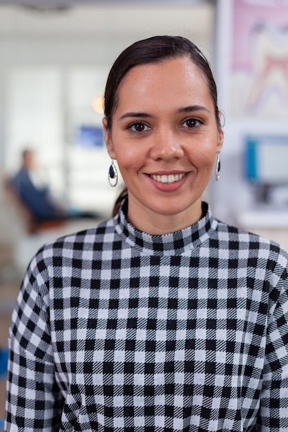 Foto grátis retrato de paciente mulher sorridente, olhando para a câmera, sentado na cadeira, na sala de espera de stomatologic.