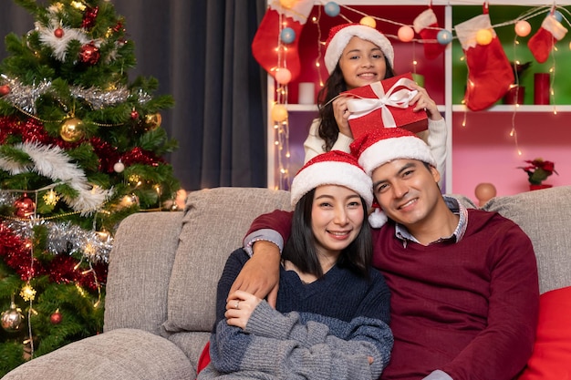 Retrato de pai de família feliz, mãe e filha, celebram o Natal na temporada de férias da sala de estar