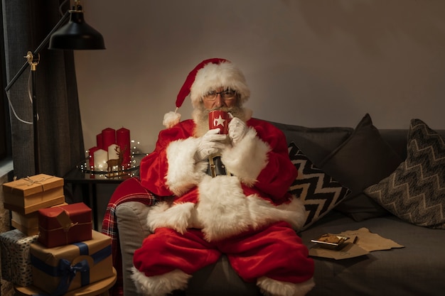 Foto grátis retrato de papai noel sentado no sofá