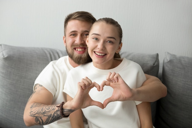 Retrato, de, par feliz, abraçando, fazer, coração, com, mãos