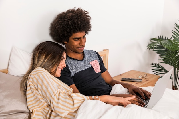 Foto grátis retrato, de, par interracial, usando computador portátil, junto