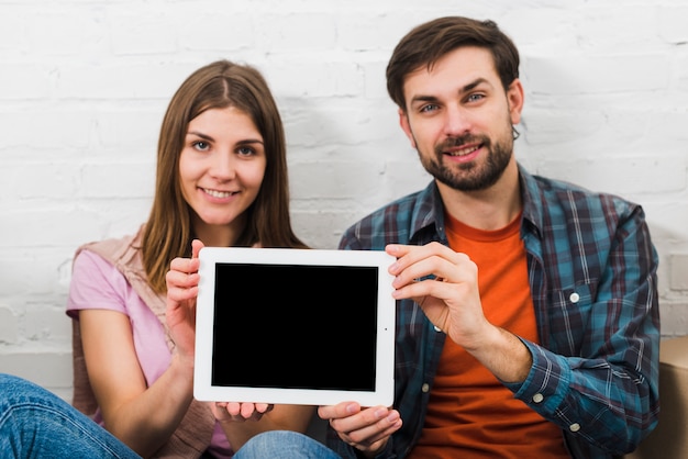 Retrato, de, par jovem, mostrando, tablete digital, frente, câmera