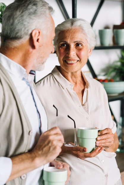 Foto grátis retrato, de, par velho, xícara segurando café, olhando um ao outro