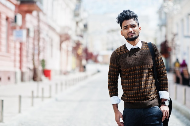 Foto grátis retrato de pose de modelo de jovem indiano elegante na rua