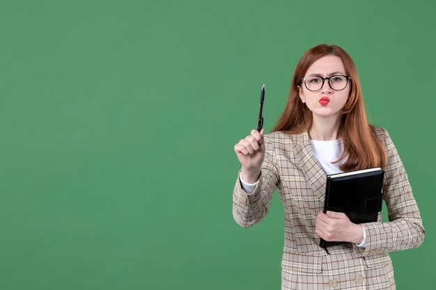 Retrato de professora com bloco de notas com cara séria em verde