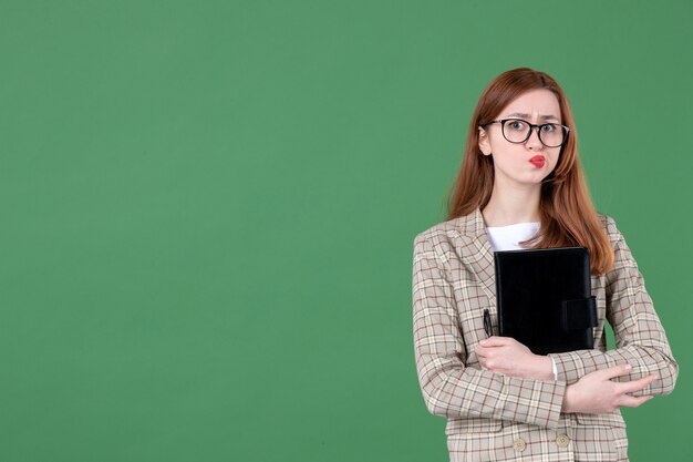 Retrato de professora com bloco de notas confuso em verde