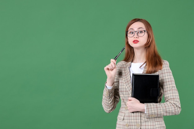 Retrato de professora segurando o bloco de notas verde