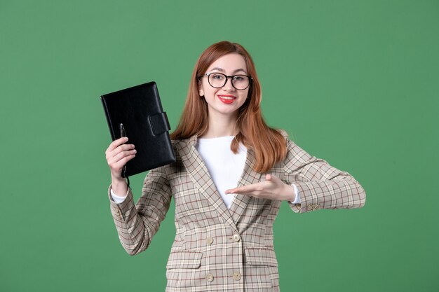 Retrato de professora segurando o bloco de notas verde